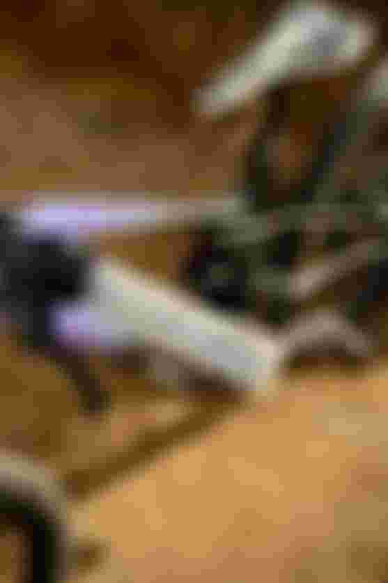 Close-up of a mountain bike on sandy terrain, highlighting the textured handlebar grips and saddle, with soft sunlight casting shadows.