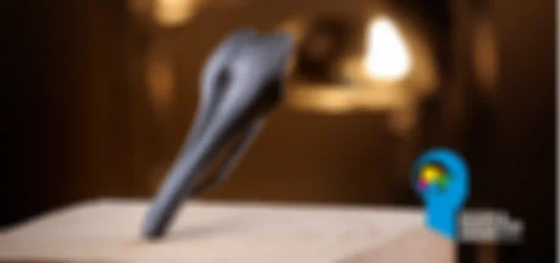 A sleek black bicycle saddle on a wooden surface, with a "Design & Innovation Award 2026" logo in the lower right corner.