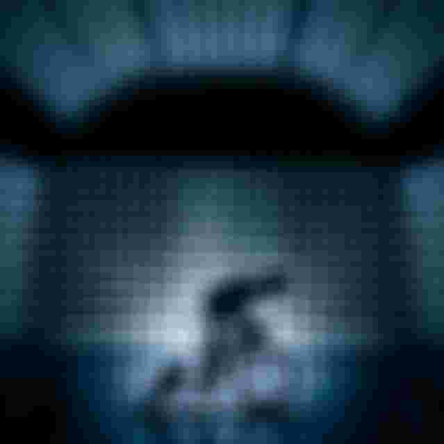 Silhouette of a person cycling indoors, surrounded by geometric, pyramid-shaped panels, creating a futuristic and symmetrical ambiance.