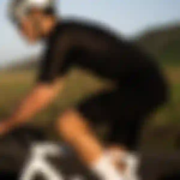 A cyclist wearing black gear and a white helmet rides a white bike on a road with grassy hills in the background.