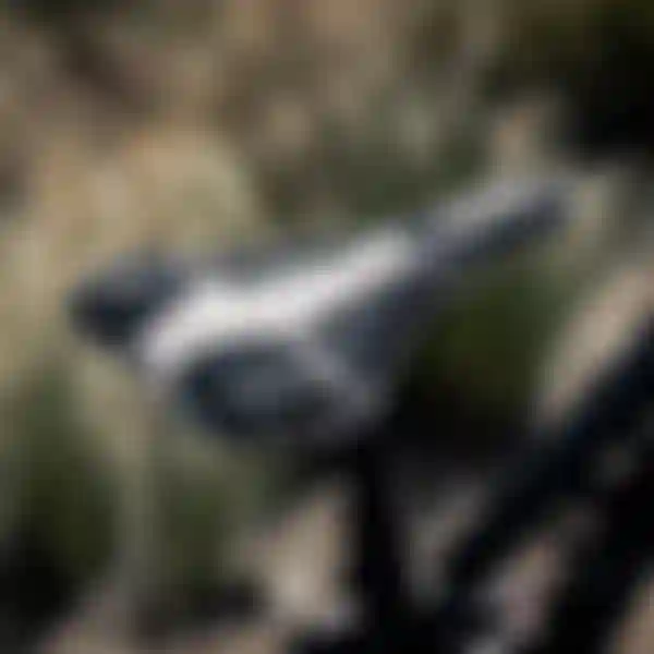 Close-up of a bicycle saddle with a black and white camouflage pattern, attached to the bike post, with blurred outdoor background.