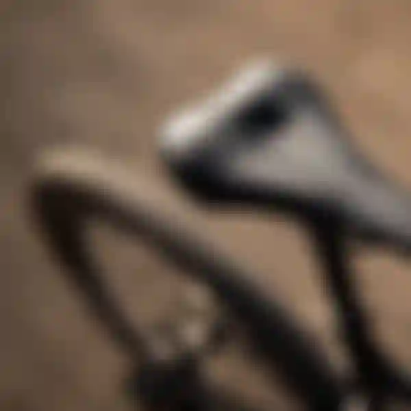 Close-up of a black bicycle saddle with perforated design and branding, mounted on a bike, with blurred background.