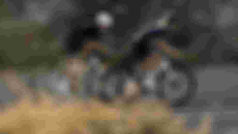 Zwei Rennradfahrer auf einer Straße, seitlich fotografiert mit Bewegungsunschärfe.