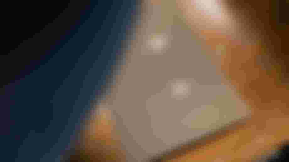 Corrugated cardboard sit bone measurement tool placed on a wooden surface, with two circular impressions indicating the rider’s sit bone distance.