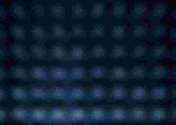 Abstract pattern of illuminated, pyramid-like shapes in a grid, with a blue and dark color palette, creating a textured effect.