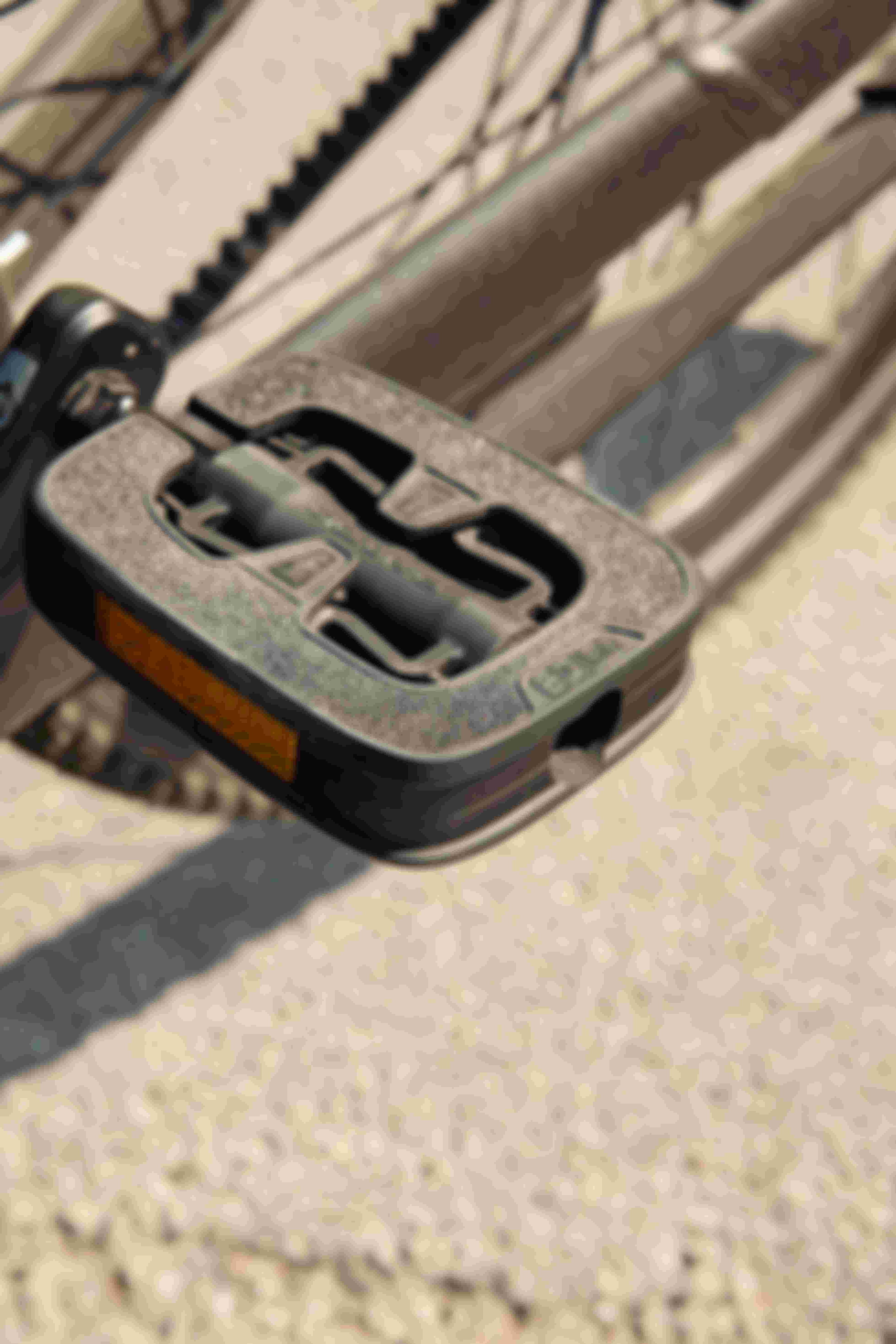 Close-up of a trekking bike pedal with textured platform and reflector, designed for stable footing and a natural foot position.