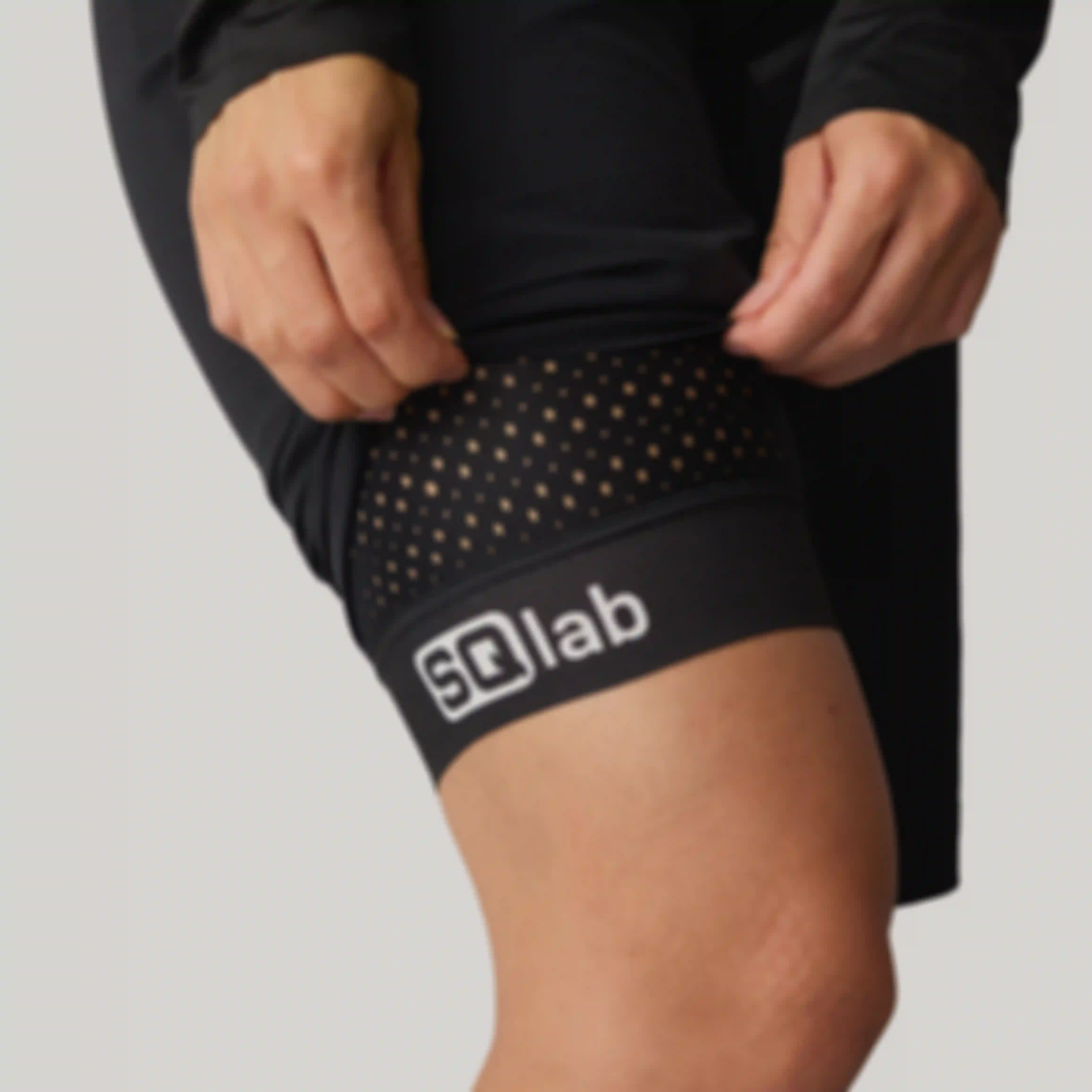Close-up of the leg cuff on SQlab ONE10 cycling shorts, showing perforated fabric and SQlab logo.