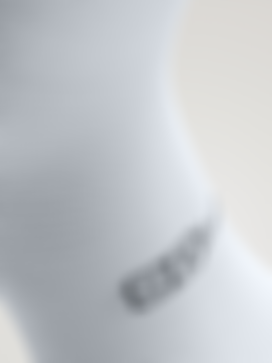 Close-up of a white cycling sock showing fine knit texture and the SQlab logo near the ankle.