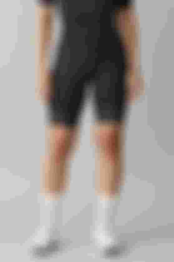 Female cyclist wearing black SQlab ONE12 shorts, standing front-facing.