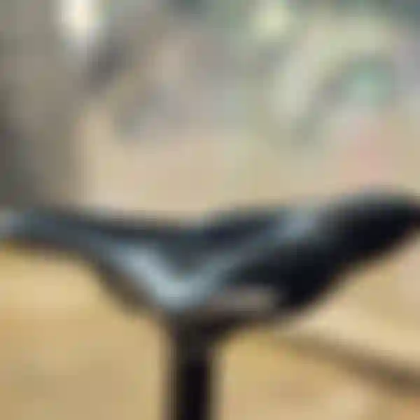 Close-up of a sleek black SQlab bicycle saddle with blurred lights in the background.