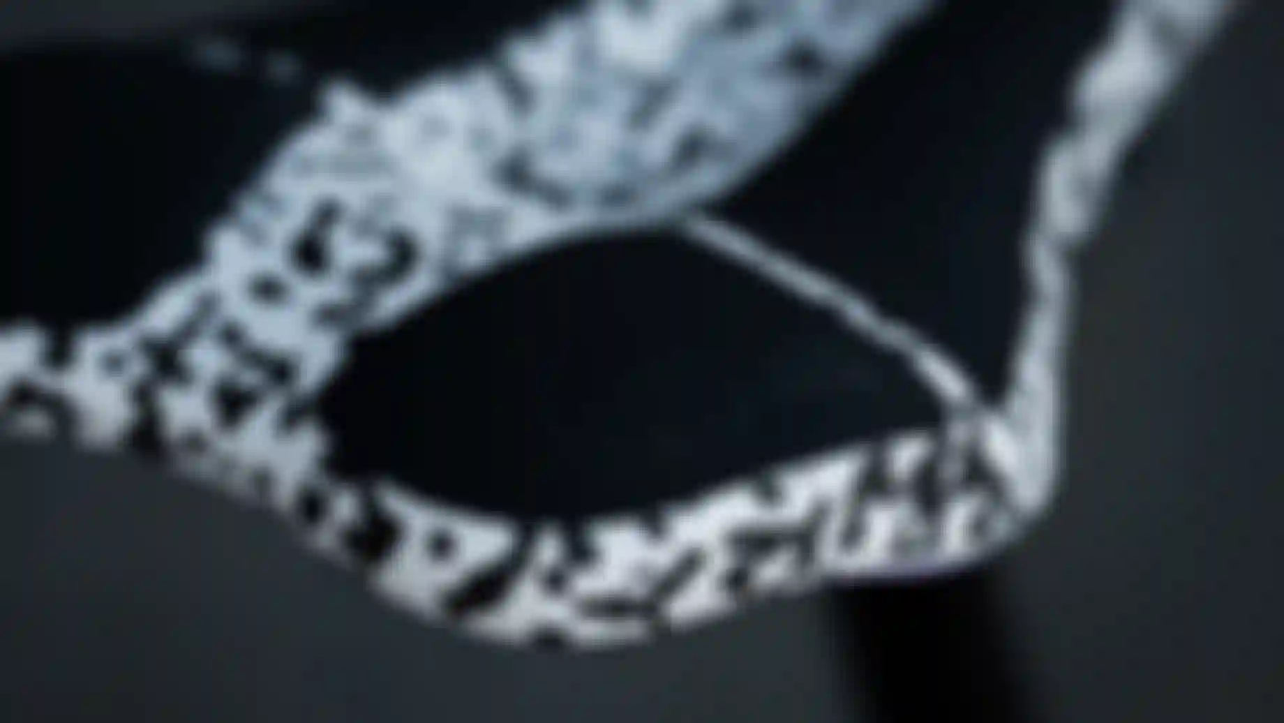 Close-up of the rear section of a black and white speckled SQlab saddle, highlighting the textured Infinergy® padding insert with subtle SQlab logo on the saddle tail.
