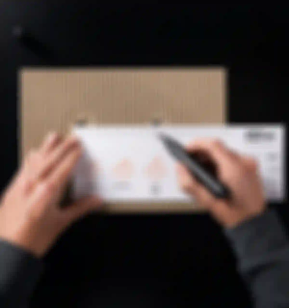 A person measures a cardboard piece with a ruler and marker, displaying bicycle drawings and measurements.