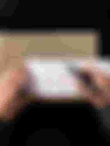 A person measures a cardboard piece with a ruler and marker, displaying bicycle drawings and measurements.