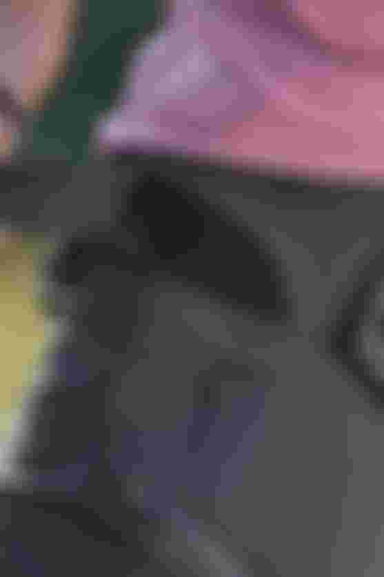 Close-up of a cyclist adjusting the waistband of MTB pants with Velcro closure, showing secure fit, stretch material, and integrated pocket detail.