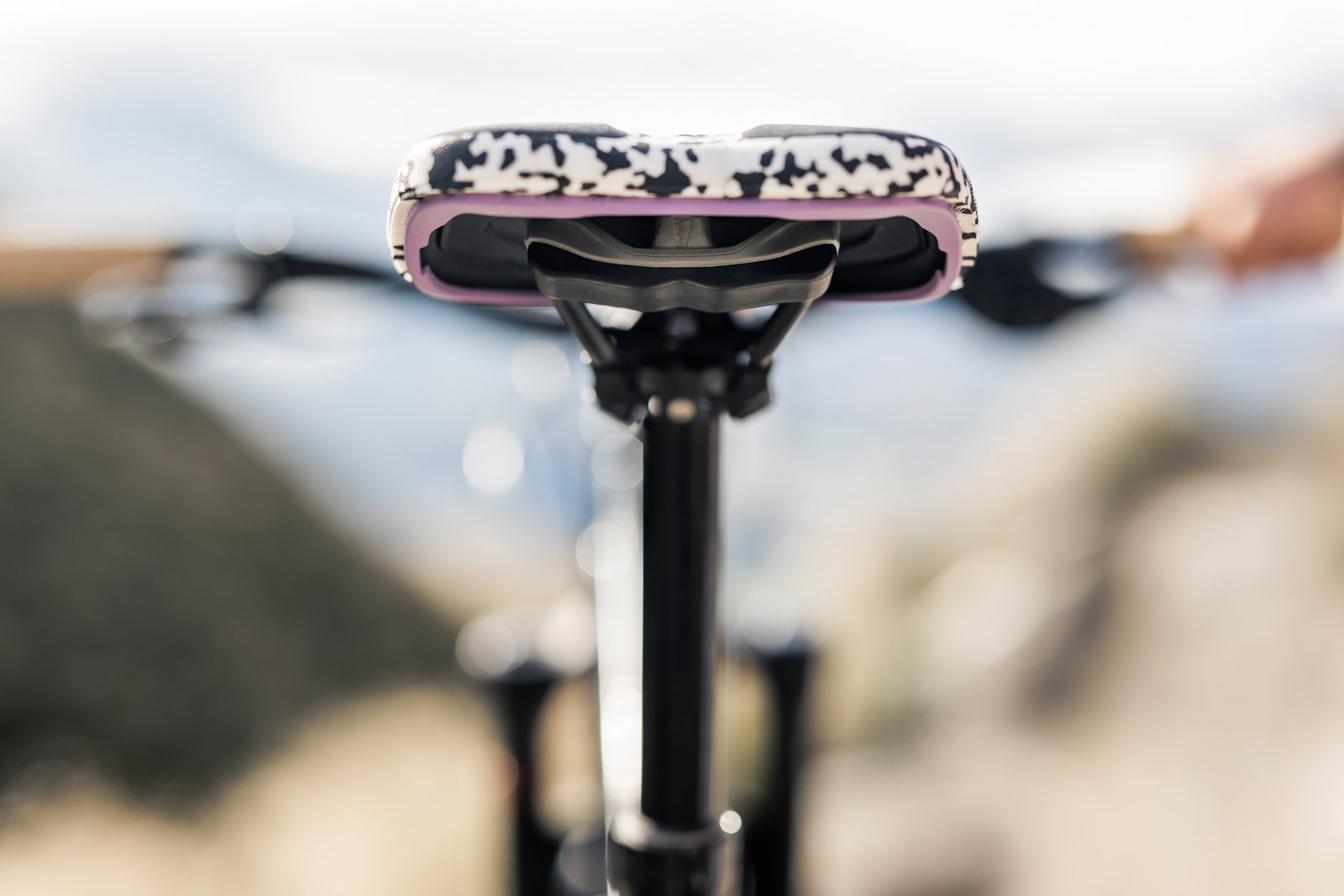 SQlab ClipOn 611 Infinergy ERGOWAVE active MTB saddle in black and white with pink trim mounted on seatpost