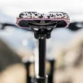 SQlab ClipOn 611 Infinergy ERGOWAVE active MTB saddle in black and white with pink trim mounted on seatpost