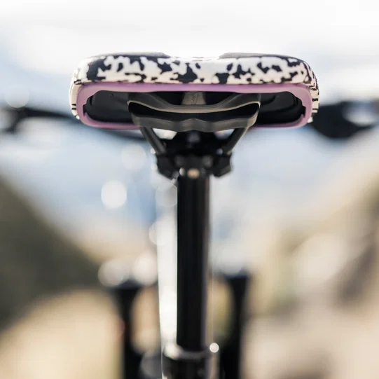 SQlab ClipOn 611 Infinergy ERGOWAVE active MTB saddle in black and white with pink trim mounted on seatpost