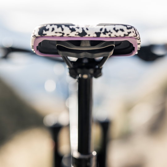 SQlab ClipOn 611 Infinergy ERGOWAVE active MTB saddle in black and white with pink trim mounted on seatpost