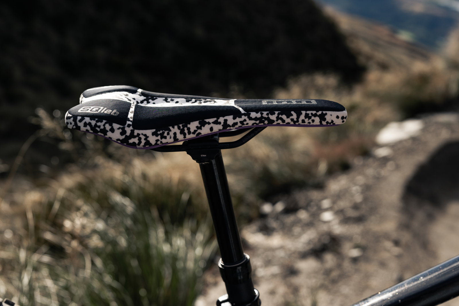 SQlab 611 ERGOWAVE Infinergy MTB saddle in black and white on mountain trail