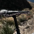 SQlab 611 ERGOWAVE Infinergy MTB saddle in black and white on mountain trail