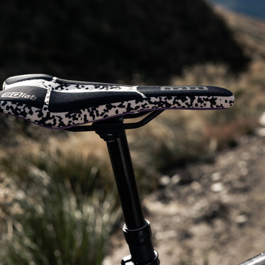 SQlab 611 ERGOWAVE Infinergy MTB saddle in black and white on mountain trail