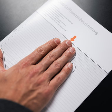 SQlab Measure at Home Set grip width determination sheet in use with hand placed flat