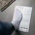 SQlab Measure at Home Set foot type guide with foot in white sock placed on instruction sheet