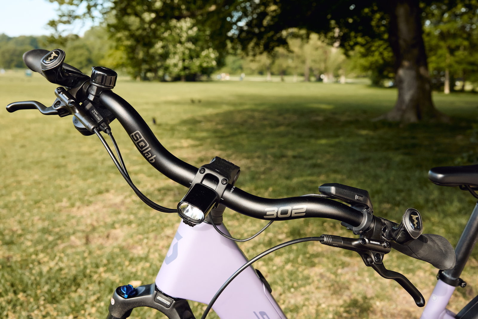 SQlab 302 trekking handlebar 31.8mm in matte black mounted on a trekking bike in a park